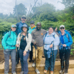A group of trekkers posing for a photo with forest in the background.