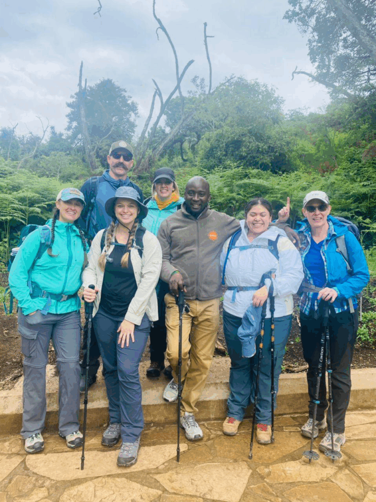 A group of trekkers posing for a photo with forest in the background.