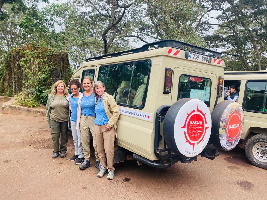 Women standing beside a safari jeep in Tanzania