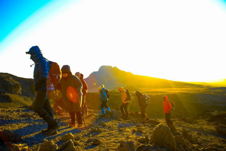 A group of hikers making their way up Mt. Kilimanjaro, surrounded by mountain terrain and mist during a guided trek with Nakuja Expeditions.