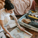 A tourist organizing clothing and safari gear in a suitcase, preparing for an African safari adventure.