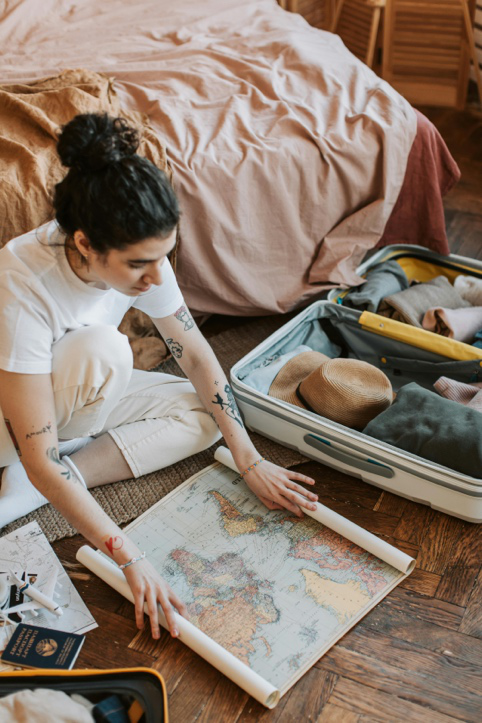 A tourist organizing clothing and safari gear in a suitcase, preparing for an African safari adventure.